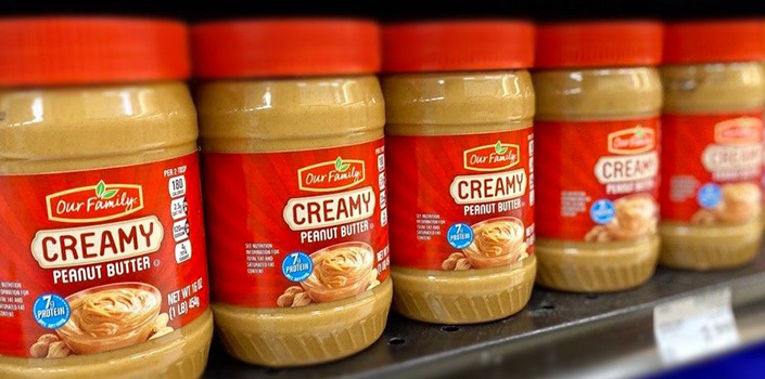 Our Family creamy peanut butter on shelf at retail store
